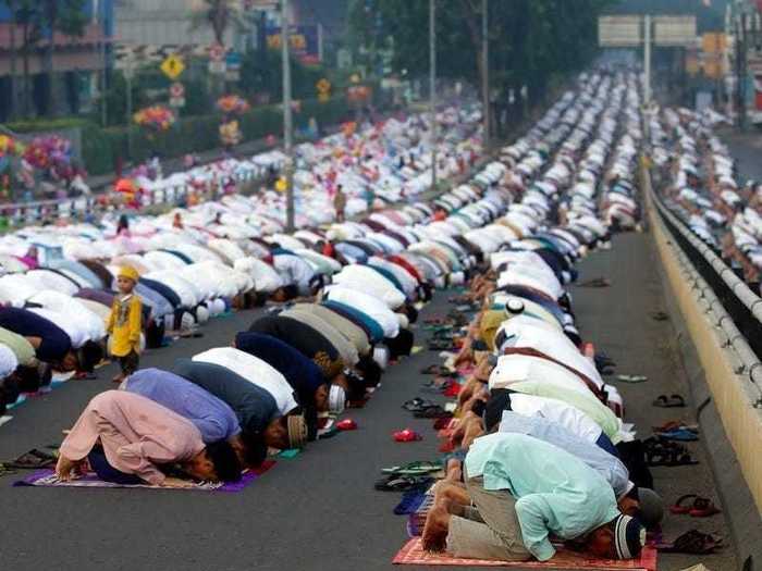 In Jakarta, Indonesia, individuals gather on a street to perform an Eid al-Fitr prayer.