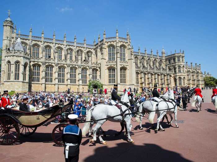 Similarly, this photo of the Duke and Duchess of Sussex in their wedding carriage shows the beautiful chapel and fans behind them.