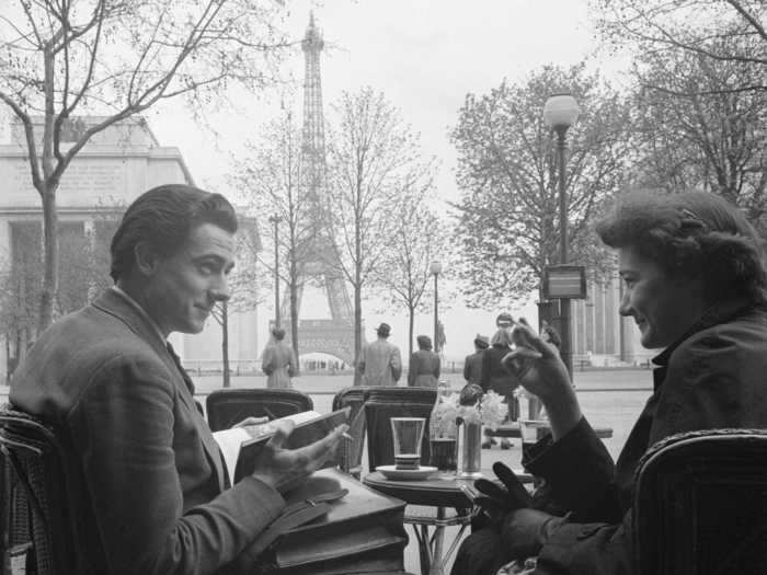 And here, a young couple sits outside at a Parisian cafe overlooking the Eiffel Tower in 1950.