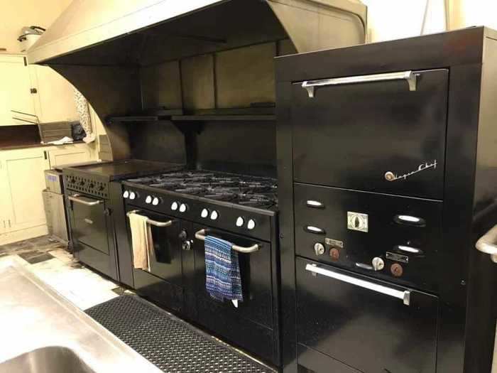 Behind the stage in the basement is a large commercial kitchen with six ovens, a 10-burner stove, and a deep fryer.