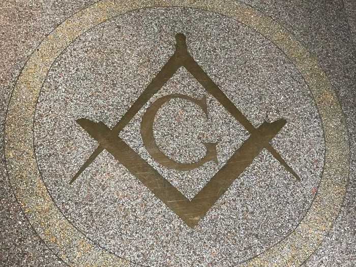 Upon entering the building, you walk into a foyer with a large Masonic symbol on the floor.