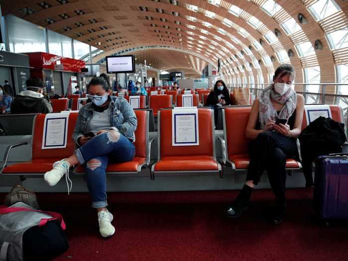 Here, passengers at Charles de Gaulle are seen spaced out every other seat.