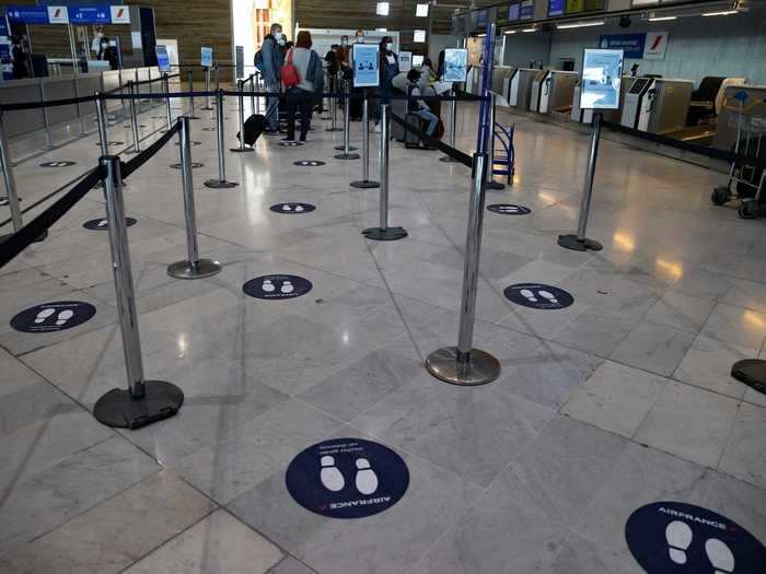 Some airports have begun implementing social distancing by using labels across the floor that tell passengers where to stand while they check in for a flight, like these at Charles de Gaulle in Paris.