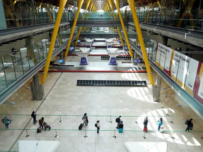 But people are still booking flights for necessary travel. In this photo at an airport in Spain, passengers are seen lining up six feet apart to check in at an otherwise empty terminal.