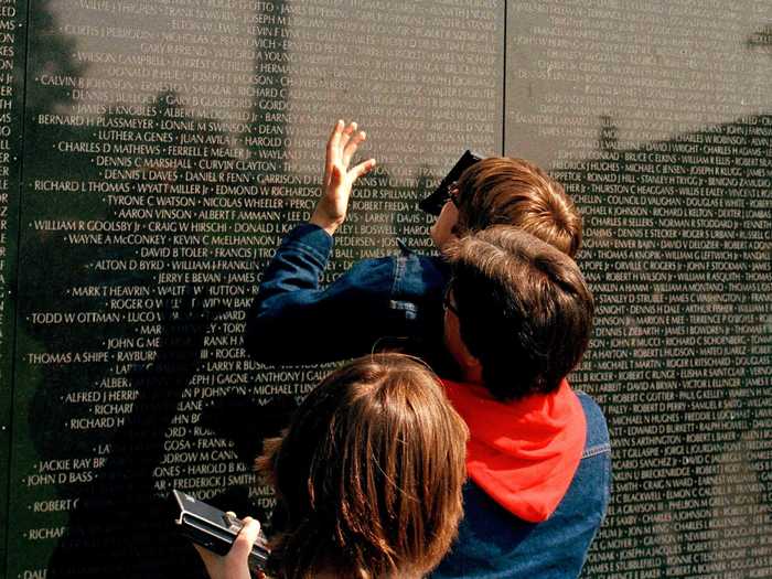 Some visit memorials in Washington, DC during the holiday weekend, like this family looking at the Vietnam Veterans Memorial in 1983.