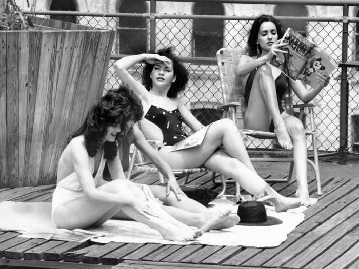 Three women enjoy the warmer weather on a New York City rooftop during the holiday weekend in 1984.