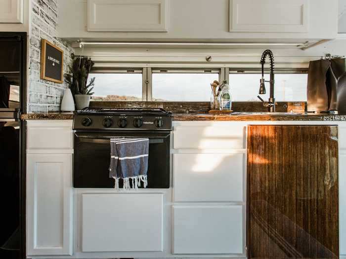 The kitchen features a full fridge, stove, and oven, and the countertops even have a personal touch.