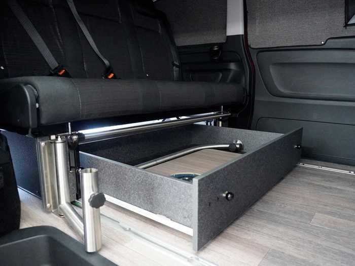 The dining table is stored and locked in a drawer underneath the seats.