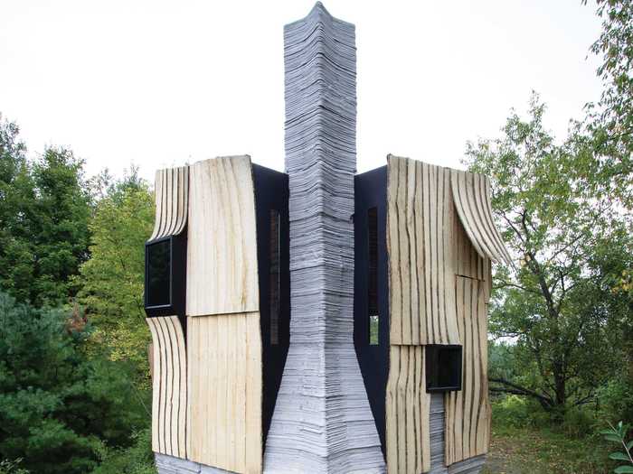 The concrete chimney, part of a working fireplace, is the most prominent feature of the exterior.