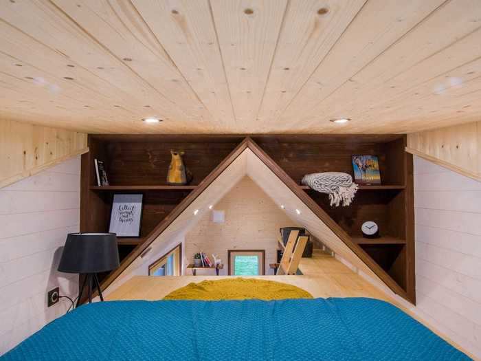 The bedroom is decorated with two built-in bookshelves and recessed LED lights.