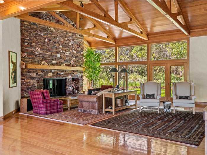 The living area has a vaulted ceiling, a wall of windows, and a fireplace.