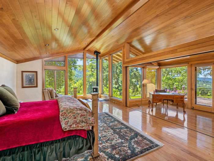 The bedroom is surrounded by windows.