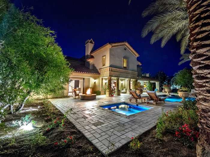 ... and the outdoor fire pit, spa, and fountain-fed pool glow by night.