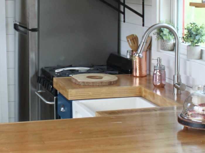 The kitchen countertop is lined with wood reused from bowling alleys, and in continuation with the tiny home