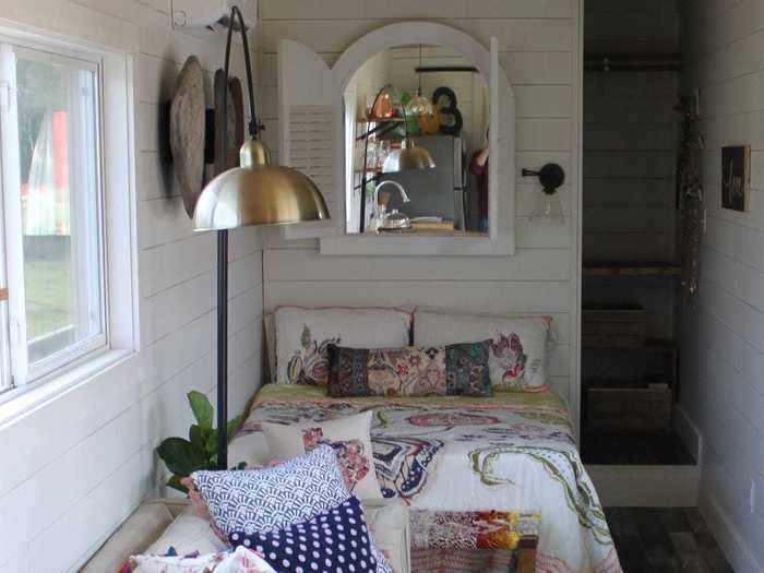 The living room includes a full-size couch that faces the television, while the bedroom has a queen bed.