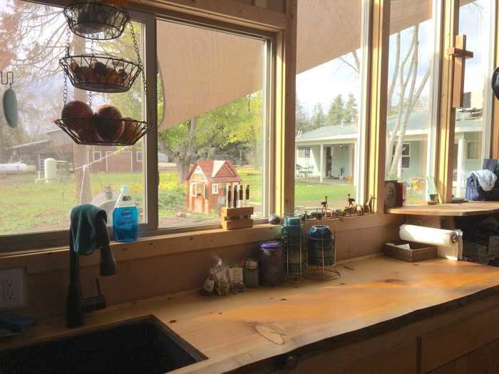 The other side of the kitchen is covered in windows that look out on the property.