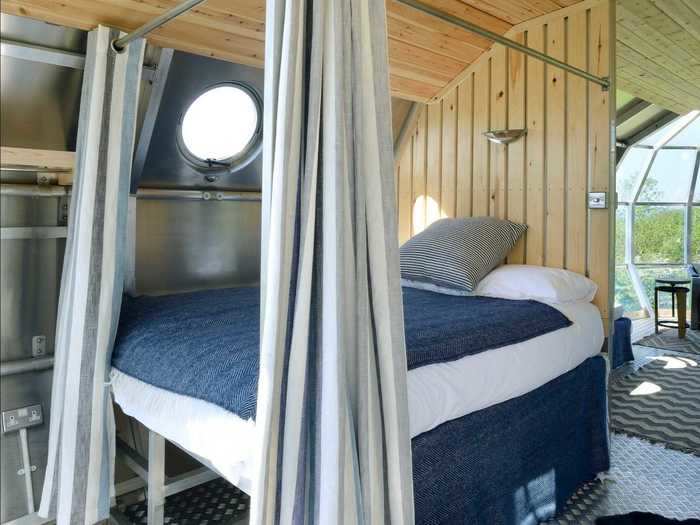 The bedroom has a double bed with storage underneath, and a curtain for privacy.