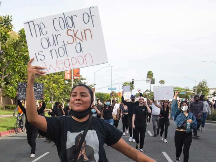 A demonstrator displayed a sign that said, "The color of our skin is not a weapon."