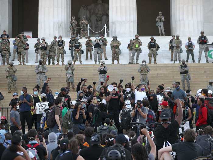 Photos show some law enforcement officials wearing "military police" vests in front of a barricade in front of the steps.