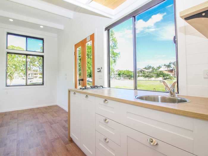 The living room, which is unfurnished, sits by the doorway at the opposite end of the home