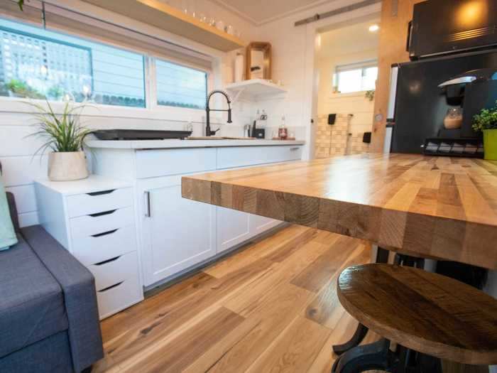 The kitchen is next to the living room and lined with storage spaces for cookware.