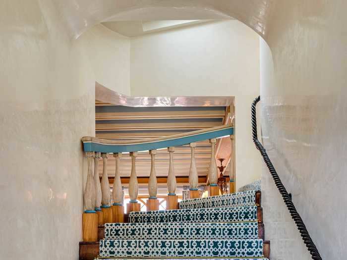 Mediterranean-style designs can be found throughout the estate, like this tile-inspired  carpeted runner that mirrors the teal accents on the banister.