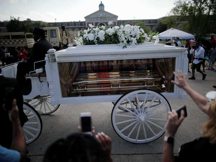 For about a mile, the white carriage took his body through crowds of people gathering to mourn and say their final goodbyes.