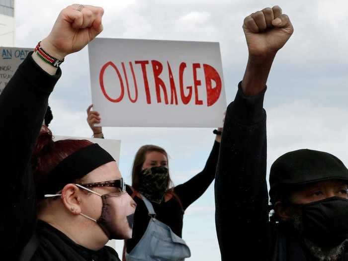 In New Hampshire, a sign reads "Outraged" as protesters gather to call for an end to police brutality.