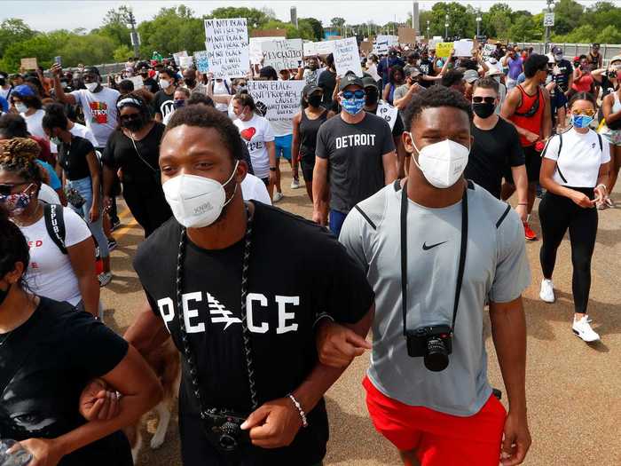 In Michigan, brothers Romeo and Julian Okwara, both members of the Detroit Lions football team, are seen marching with protesters on June 5.