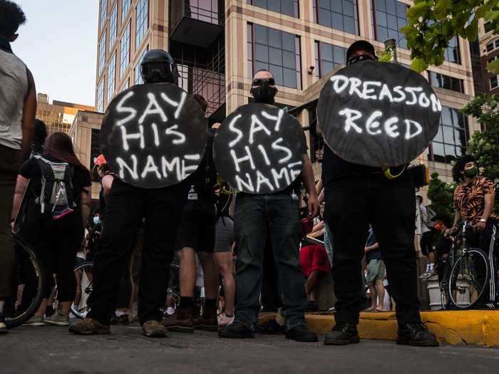 In Indiana, protesters are seen holding a sign that says "Say his name" and honoring Dreasjon Reed, a black man from Indianapolis who was killed by police in early May.