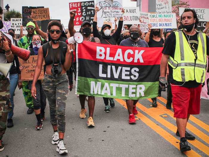 In Miami, Florida, protesters are seen carrying a Black Lives Matter sign as they march through the streets.