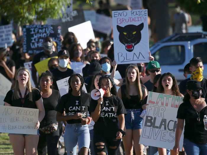 In Laveen, Arizona, protesters are seen gathering for a rally in a park before marching down the street to demand justice for police brutality.