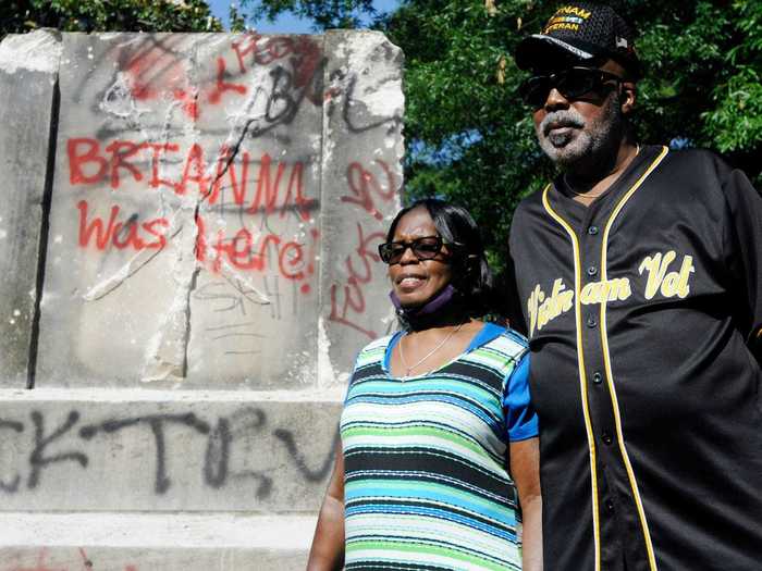 In Alabama, a couple stands in front of a Confederate memorial that protesters took  down and reclaimed on June 2.