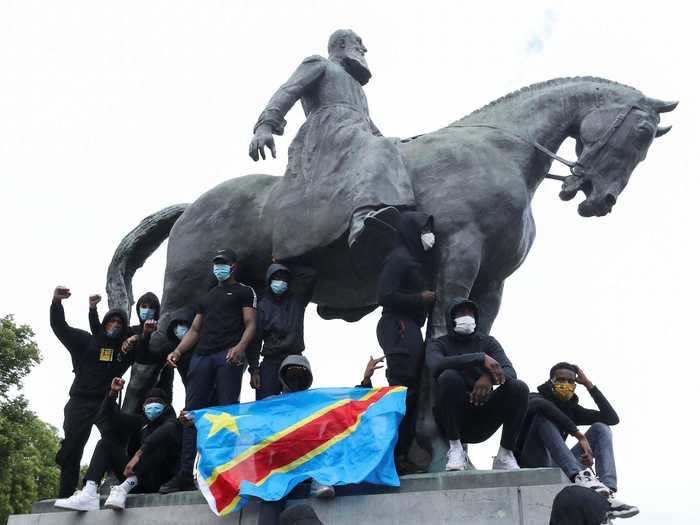 And in this photo, demonstrators hold up the flag of the Democratic Republic of the Congo at the base of a King Leopold II statue in Brussels.