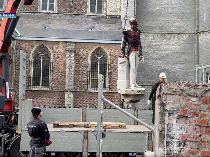 Here, a King Leopold II statue is being removed from its location in Ekeren, Belgium after protesters dumped paint over it and damaged it.