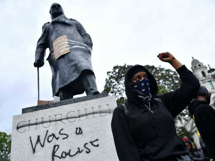 In London, protesters wrote "was a racist" underneath a monument of former Prime Minister Winston Churchill.