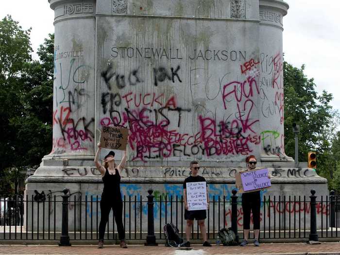 And at the Stonewall Jackson monument in the city, demonstrators are seen holding up signs as words such as "racist" adorn the statue.