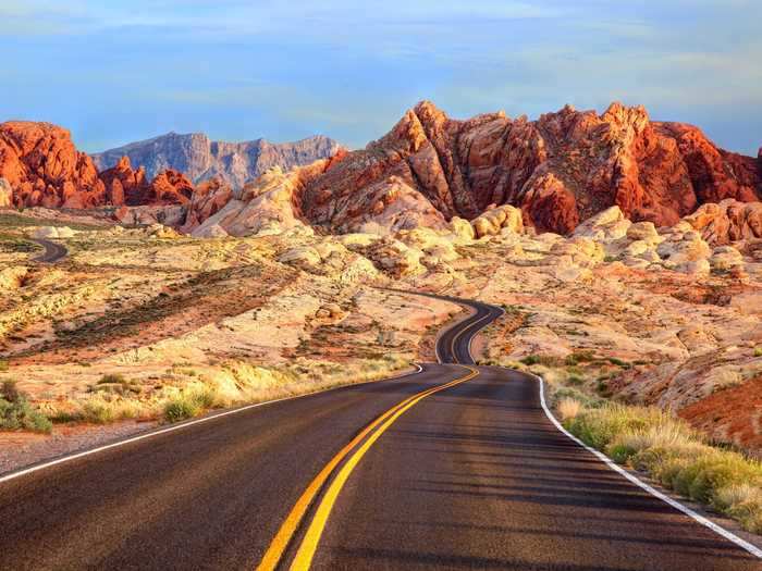 Nevada State Route 169 goes into the Valley of Fire in Nevada, which is full of bright red peaks.