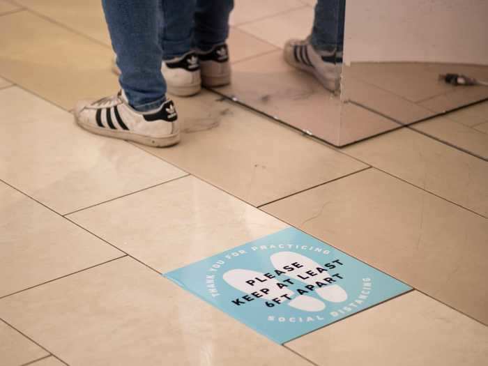 Spots on the ground mark stretches of least six feet of distance in order to keep customers apart and maintain social distancing as they wait in line.