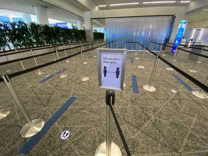 There are also reminders to social distance and placards reminding passengers where to stand. Careful consideration was given to this area which features carpeting to soften the noise levels, informational screens for each line, and plants to separate it from check-in.