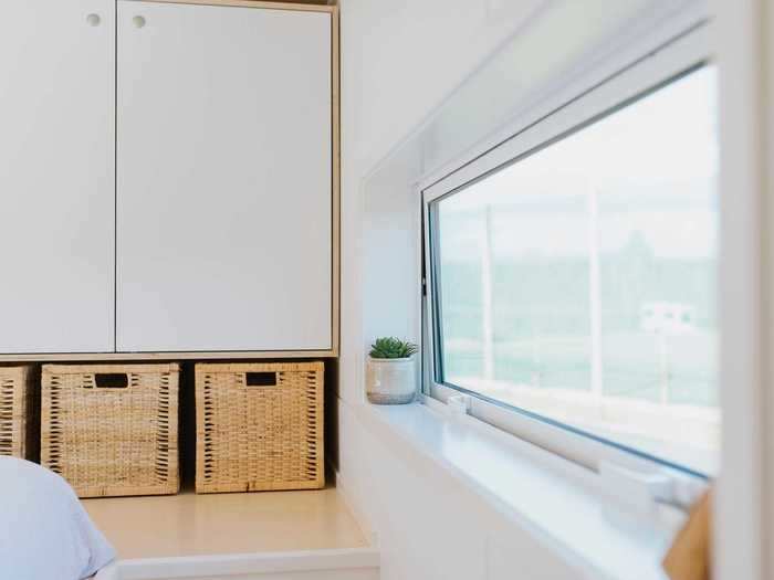 During a sunny day, the interior of the tiny home is lit with natural light through windows that are located in every room, including the bathroom and upstairs bedroom.