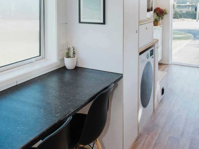 The washing machine is located next to the pantry.