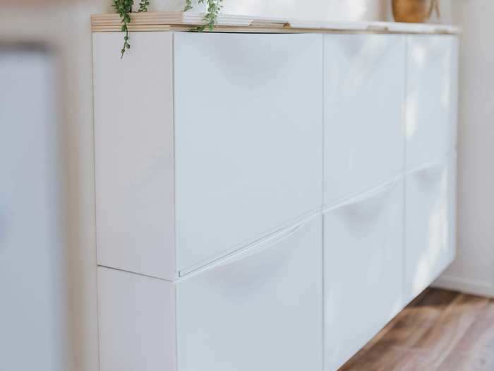 Build Tiny placed a thin fold-out storage unit, designed to store items like shoes, under the television.