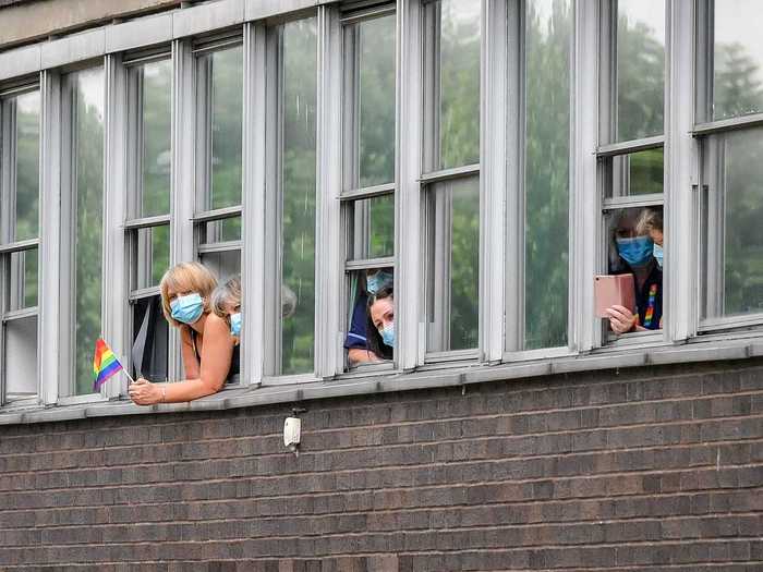 In this picture, royal fans wearing face masks try to catch a glimpse of Charles and Camilla on the ground below.