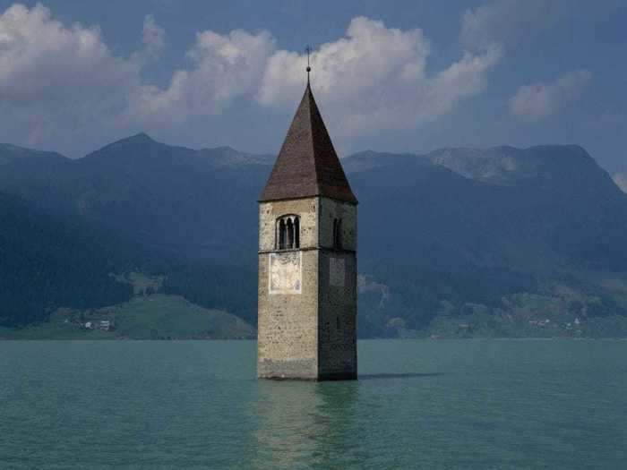 The Tower of Curon sticks out of Lake Resia, Italy, the only remnant of the town.