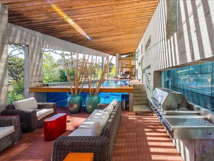 Outside, there is a covered swimming pool and large grill.