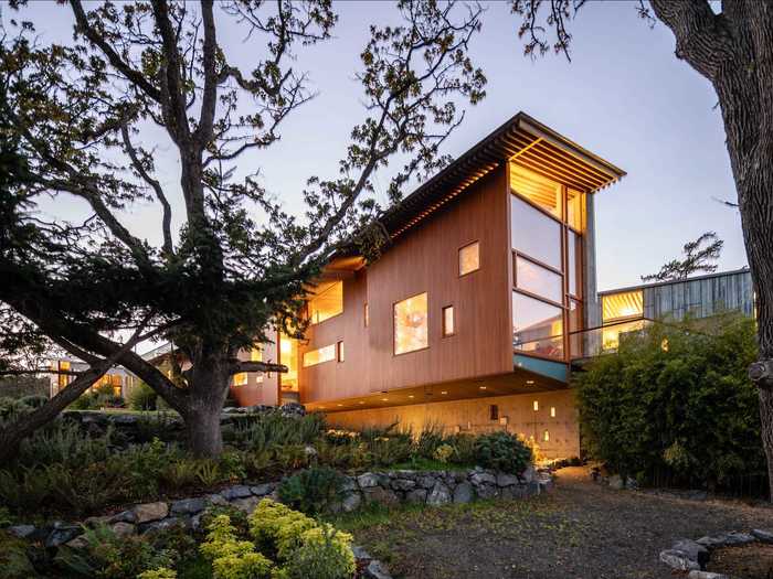 The home is "sustainably entwined" with its surroundings and is suspended in part above the ground to avoid disturbing tree roots, according to the property listing.