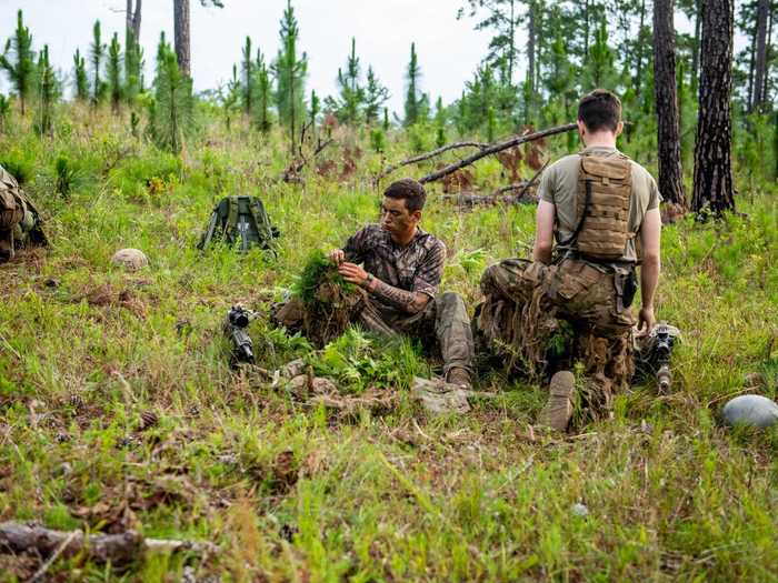 Snipers typically start the training by painting their faces and using local vegetation to camouflage themselves and their gear.