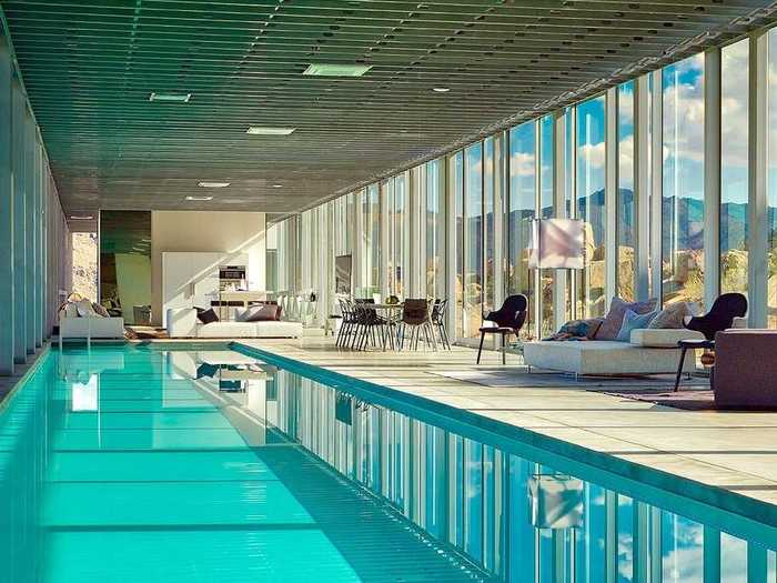 The central living space includes a 100-foot-long pool and a mix of seating areas.