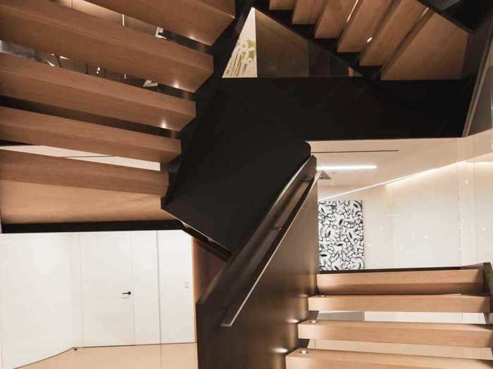 The centerpiece of the home is this glass-and-steel staircase, which connects all three stories. There are also two elevators.